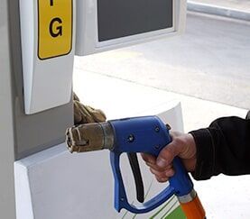 A Person is Holding a Blue Gas Pump at a Gas Station — Mechanical Repairs In Gympie, QLD