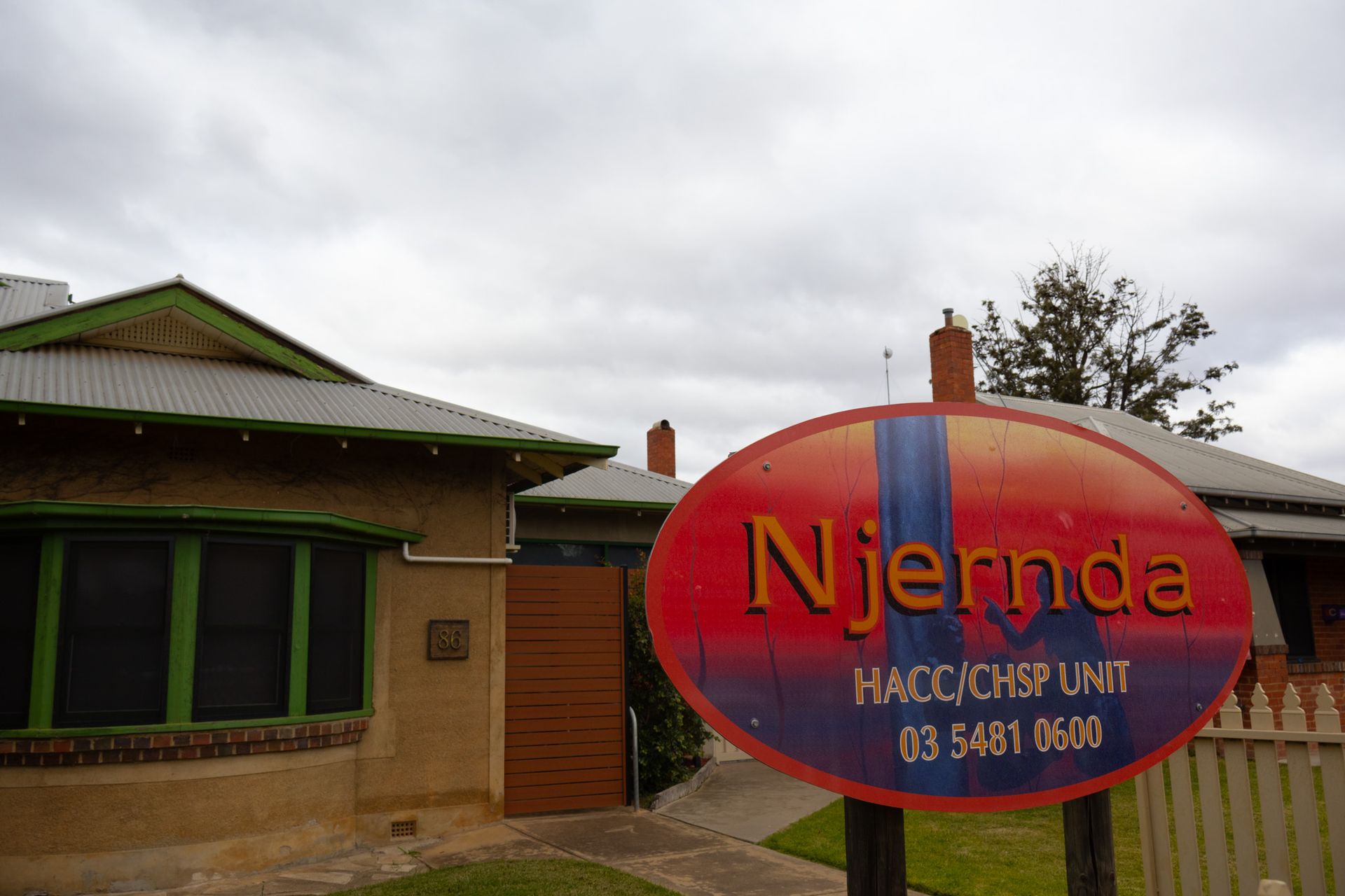 Snow-capped mountain peaks framed by dark valley sides, illuminated by golden sunlight under a blue sky.