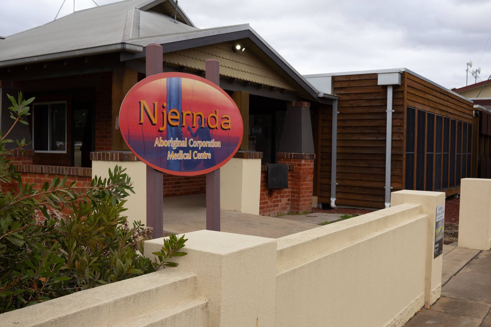 Niemda Aboriginal Corporation Medical Center sign outside a brick building with a brown wooden extension.