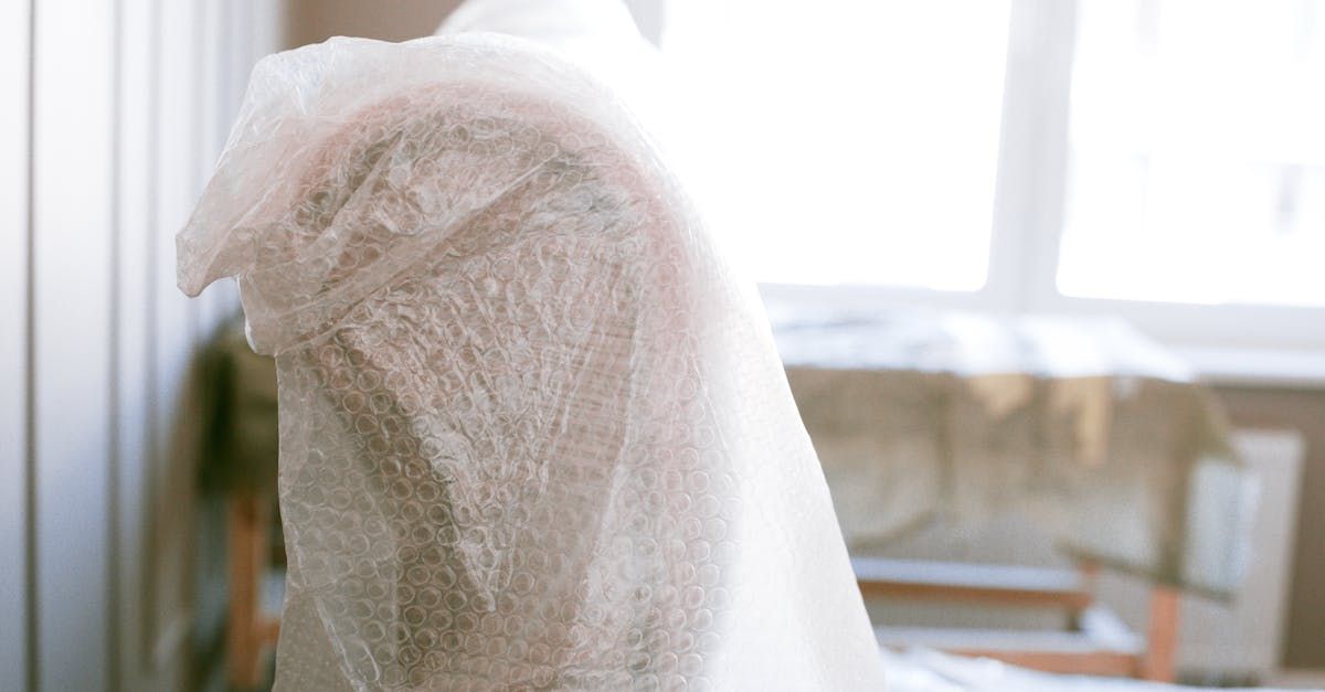 A chair is wrapped in plastic wrap in a room.