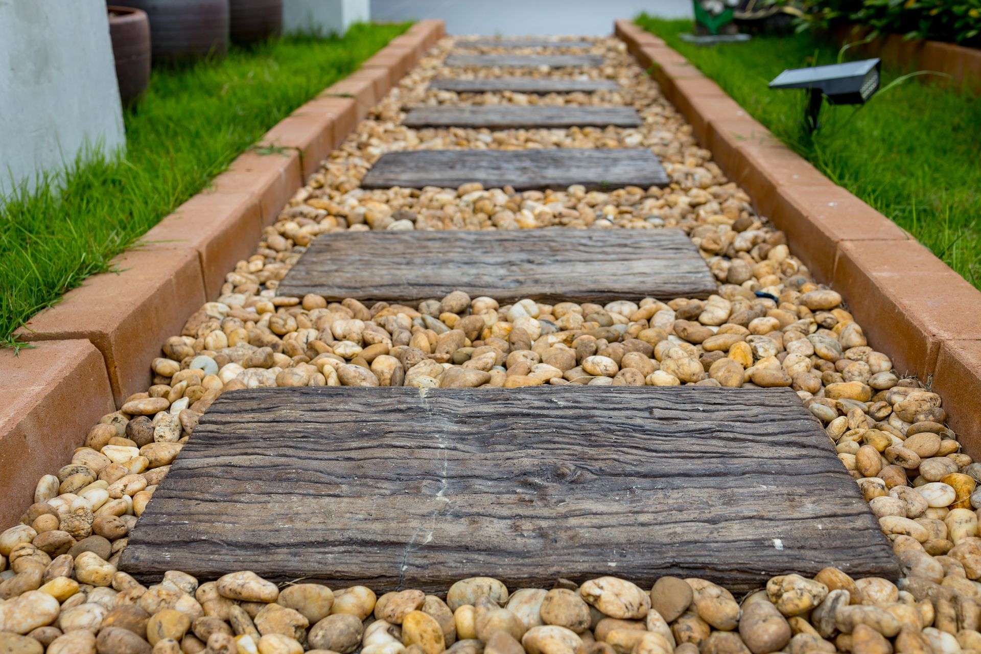 Stone Pathway With Wooden Steps and Brown Pebbles — Laurieton Landscape Supplies In Harrington, NSW