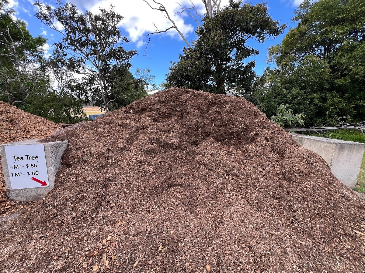 A large mound of dark brown wood mulch at an outdoor facility — Laurieton Landscape Supplies In Laurieton, NSW