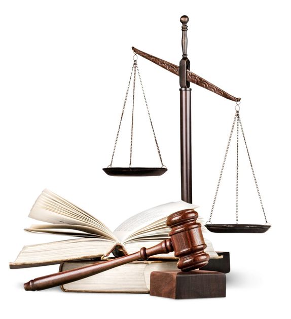 A wooden judge 's gavel sitting on top of a stack of books next to a scale of justice