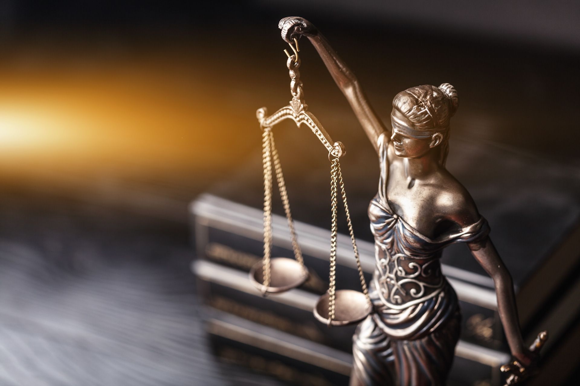A statue of justice holding a scale in front of a book
