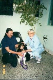 A Man Are Kneeling Down Next To A Dog On A Leash — Columbus, OH — Oakland Park Animal Hospital