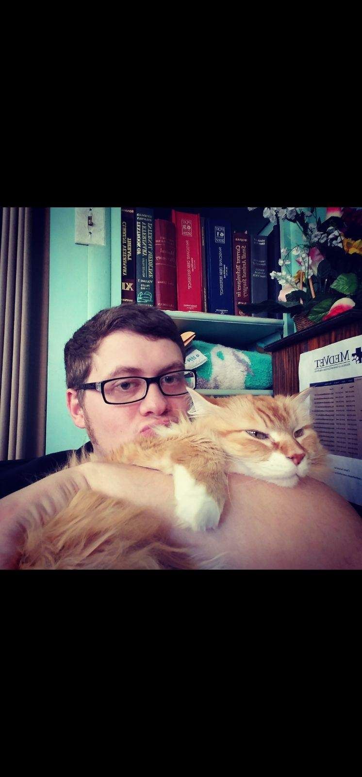 Holding A Cat On His Chest — Columbus, OH — Oakland Park Animal Hospital