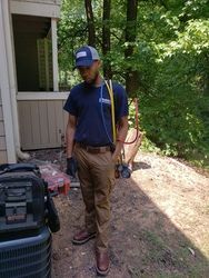 A man is standing in front of a house with a dog.