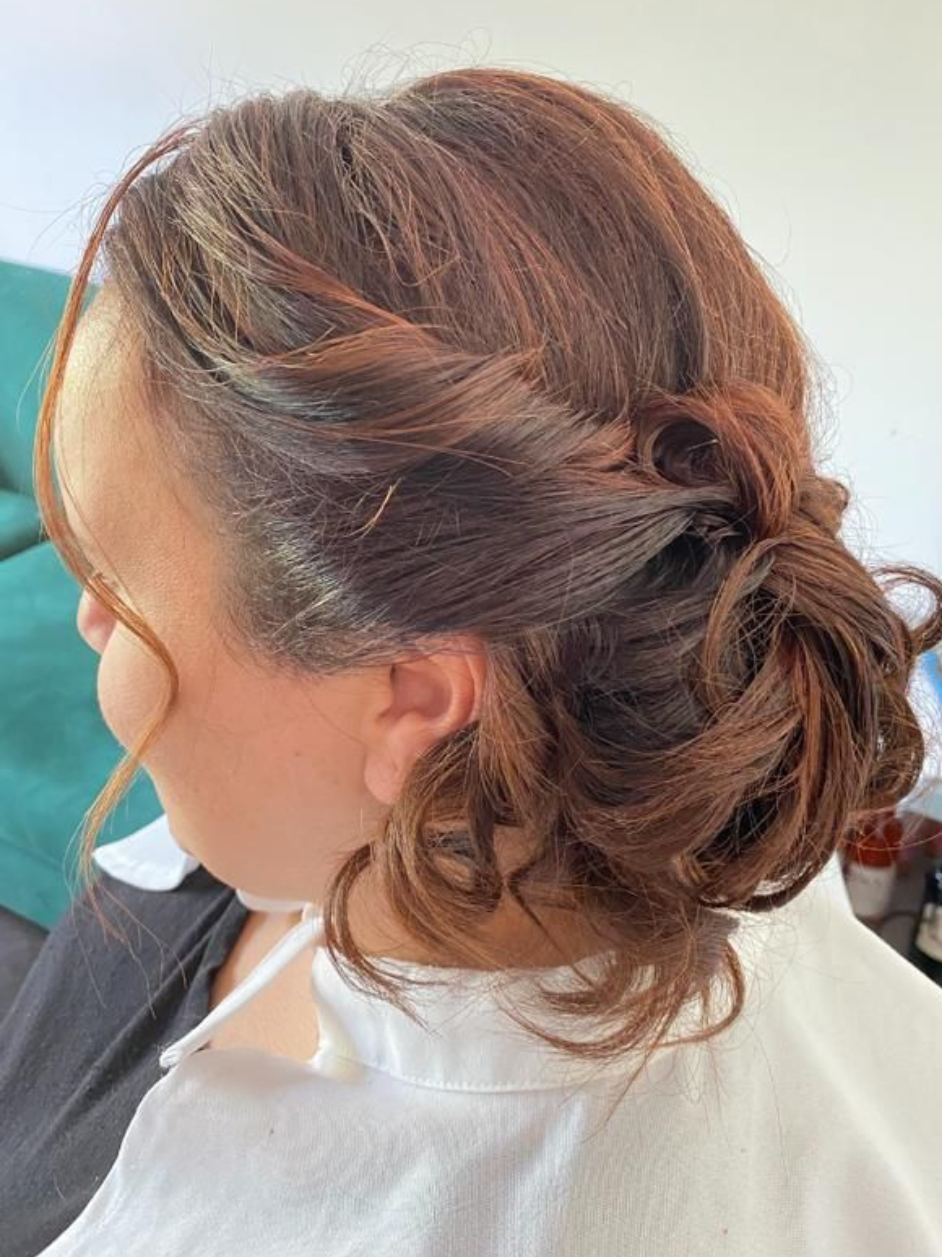 Mujer con cabello castaño rojizo recogido. Lleva una camisa blanca.