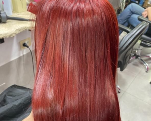Cabello largo, liso y rojo, probablemente teñido, en un salón de belleza.