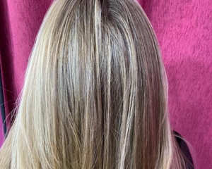 Cabello rubio, con reflejos, sobre fondo rosa.