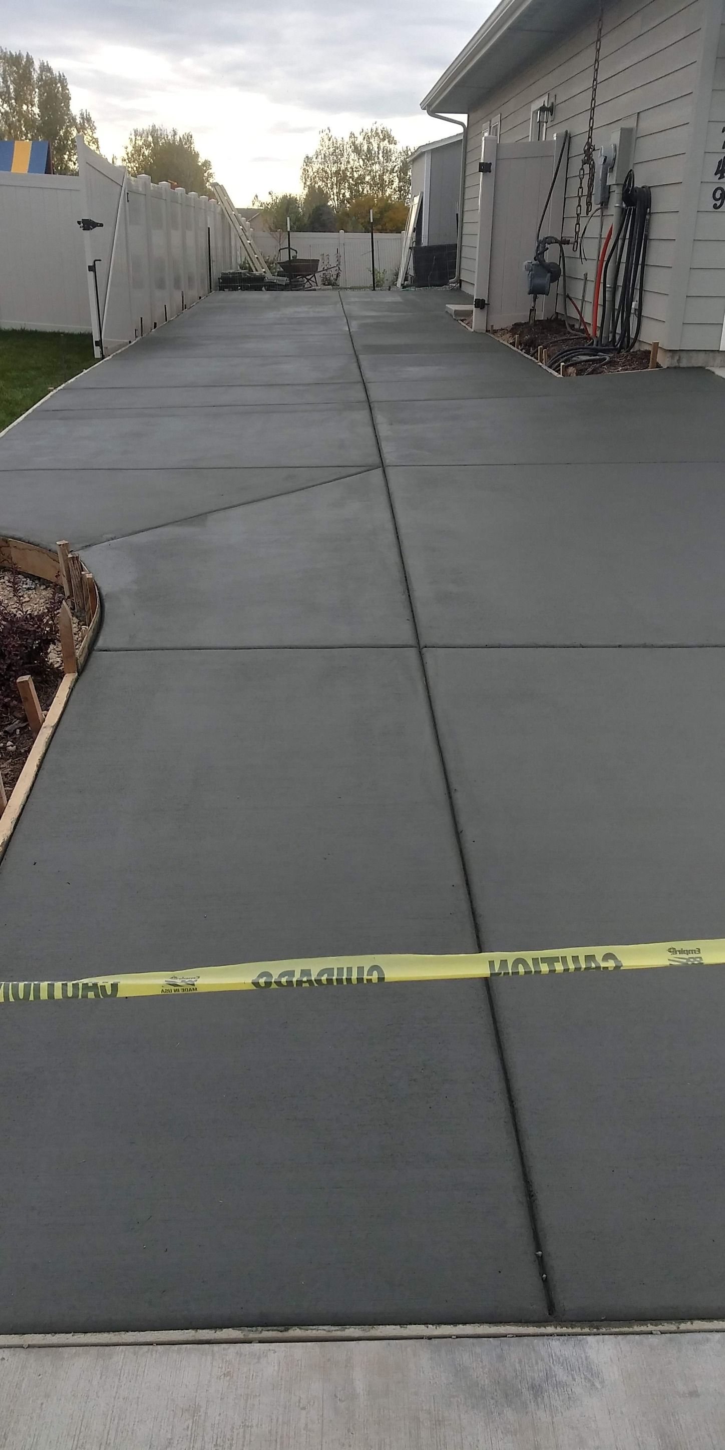 A concrete driveway is being built in front of a house.