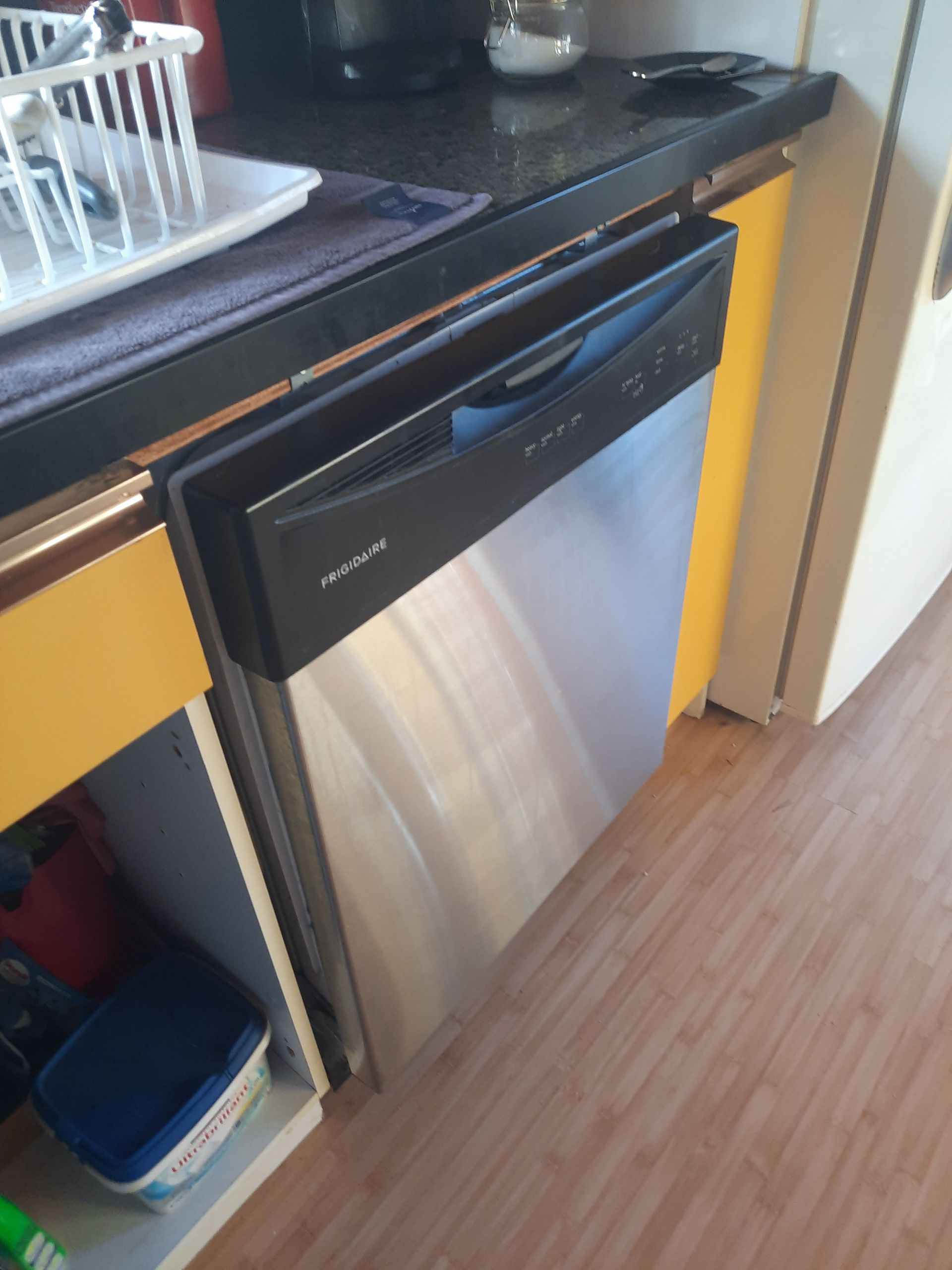 A stainless steel dishwasher is sitting under a counter in a kitchen