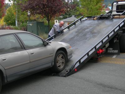 Tow Truck Operator Loading a Silver Car — Best Price Towing in Newcastle, NSW