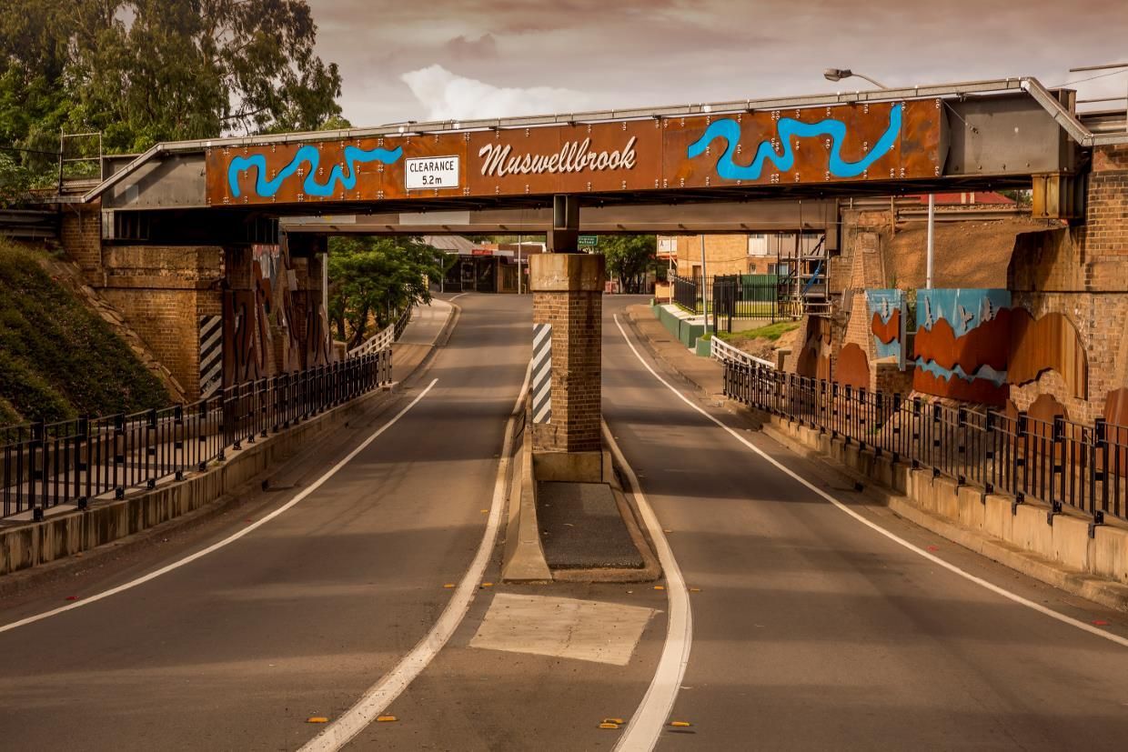 Road Underpass with Metal Bridge, Brown Brick, Graffiti Art, and Road Markings — Best Price Towing in Muswellbrook, NSW