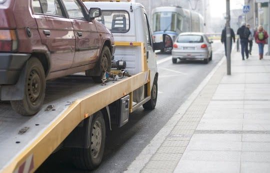 Tow Truck Loading a Red Car on a City Street — Best Price Towing in Cessnock, NSW