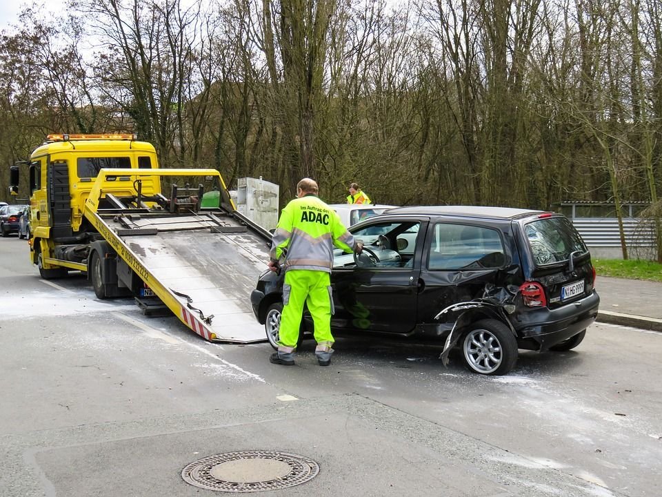 Tow Truck Loading a Damaged Black Car on a Roadside — Best Price Towing in Lake Haven, NSW