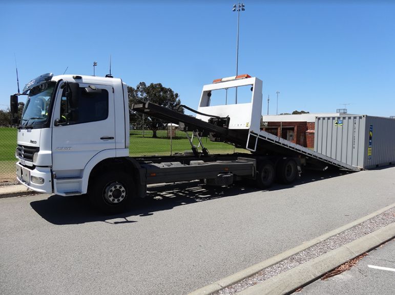 White Truck Carrying a Gray Storage Container — Best Price Towing in Morisset, NSW