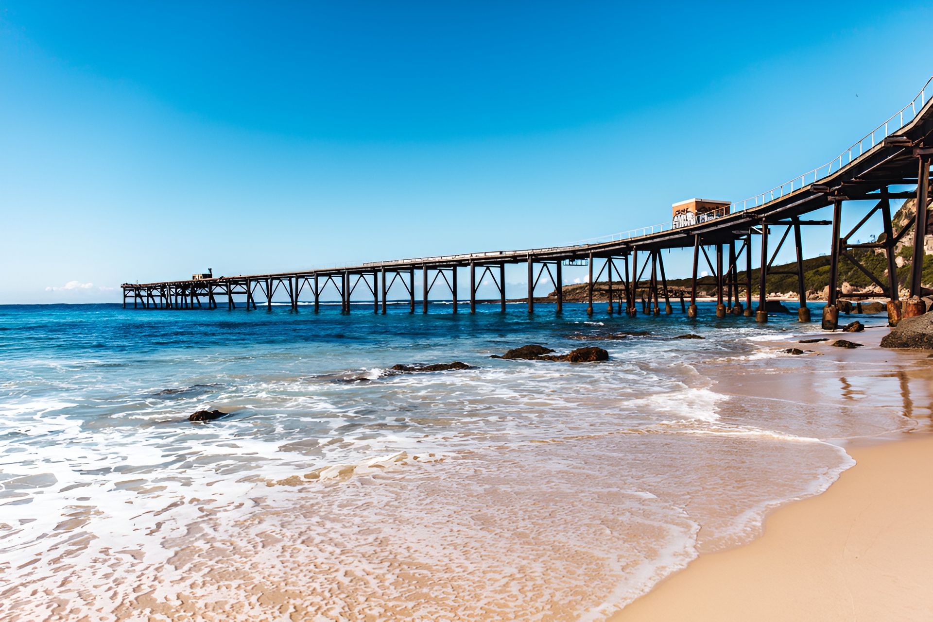 Beach Scene With Pier Extending Into Blue Ocean — Best Price Towing in Wyee, NSW