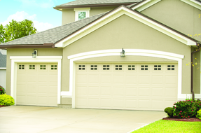 A large house with two garage doors and a driveway.