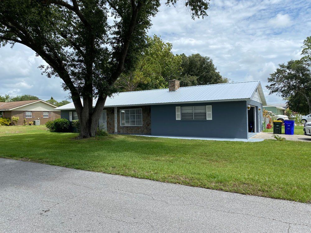 Blue House with New Roof Installed — Sebring, FL — Robert E White II Inc