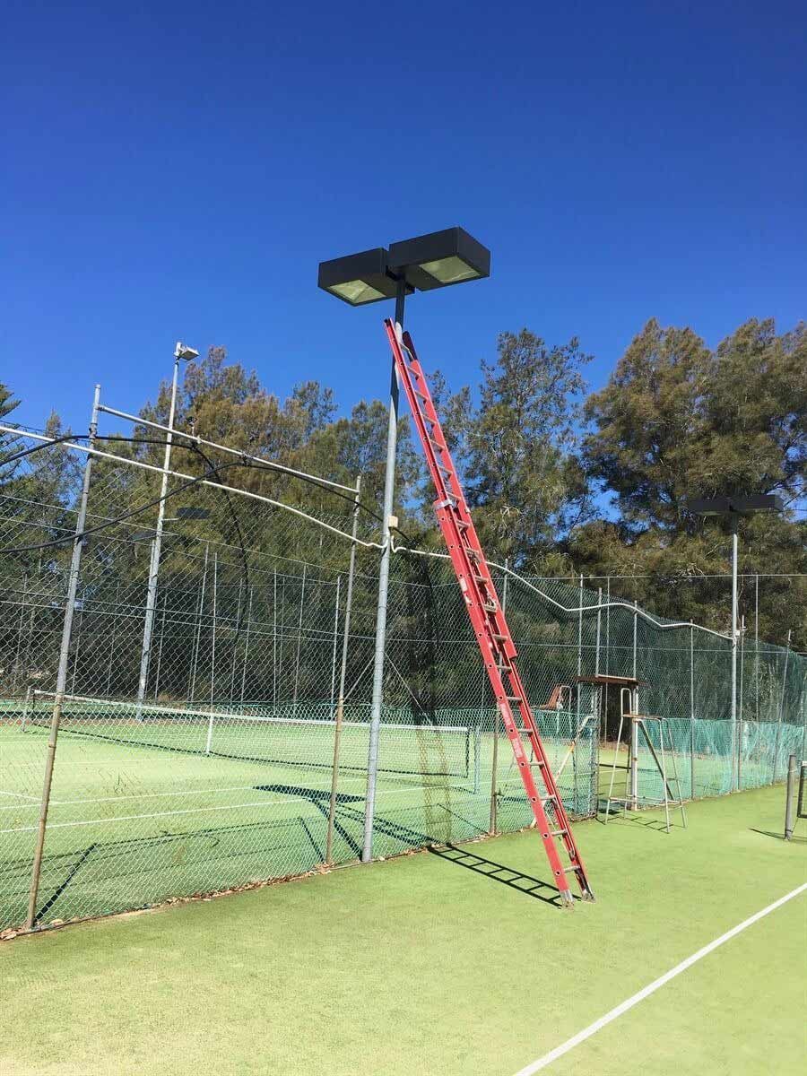 A Red Ladder Is Sitting On Top Of A Tennis Court — L.A.F Electrical P/L In Empire Bay, NSW
