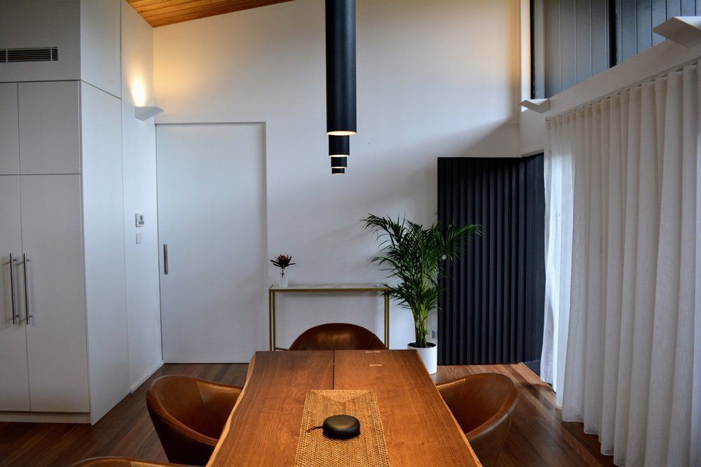 A Dining Room With A Wooden Table And Chairs And A Plant — L.A.F Electrical P/L In Avoca Beach, NSW