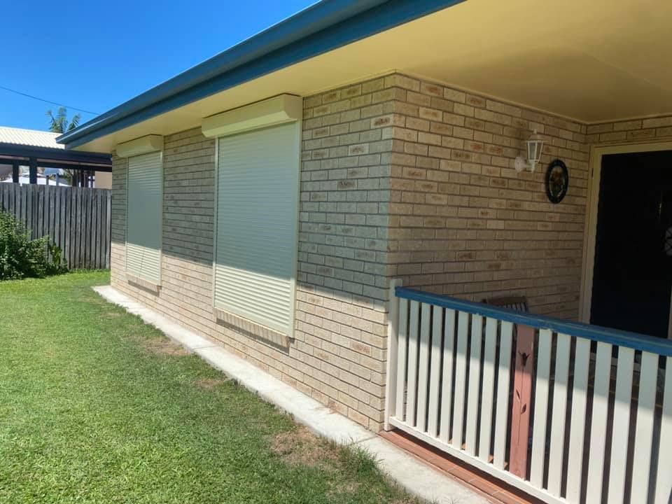 A Brick House With a White storm shutters — Whitsunday Blinds & Security In Beaconsfield, QLD