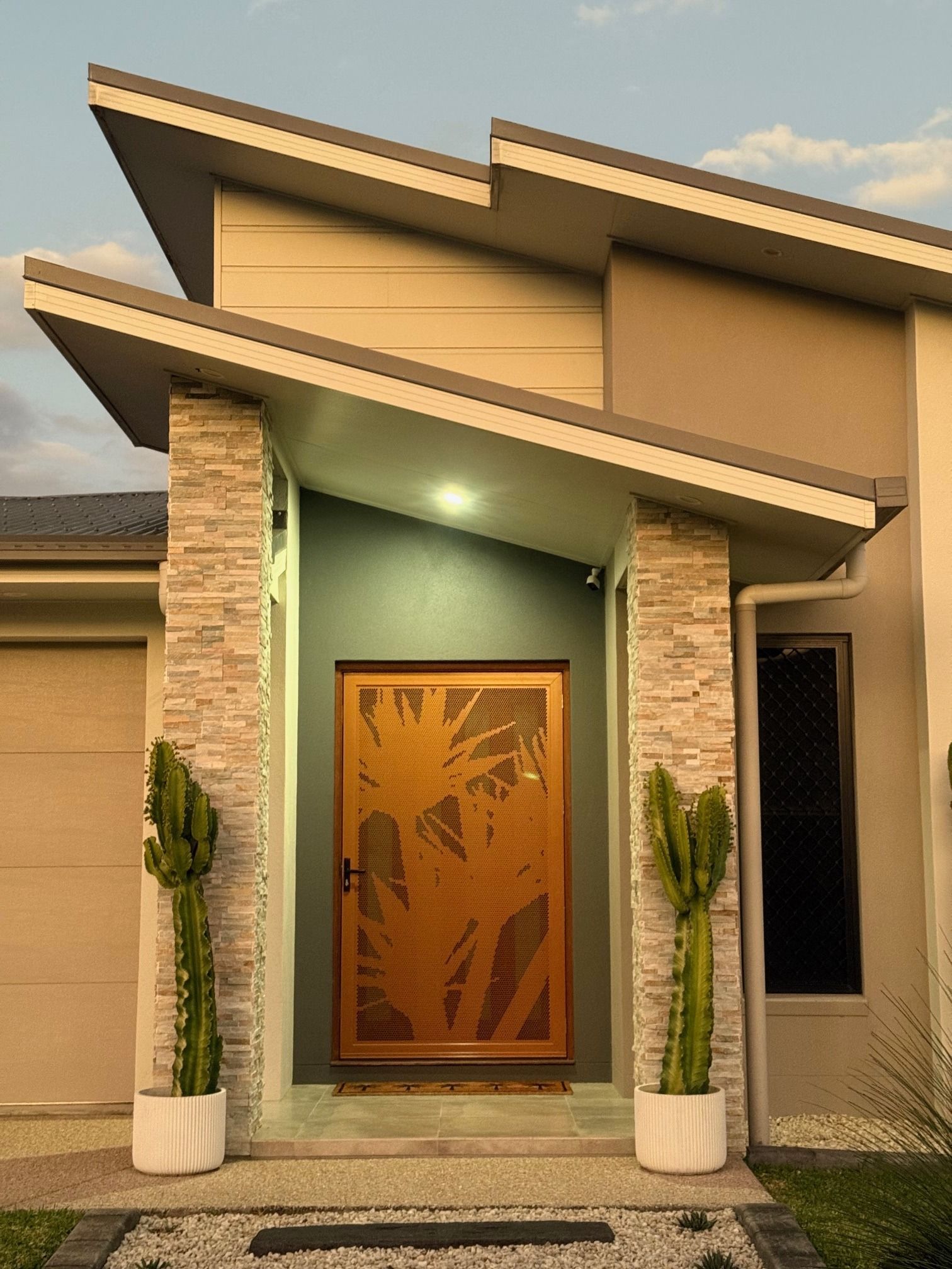 A Modern House With a Wooden Door and Cactus in Front — Whitsunday Blinds & Security In Beaconsfield, QLD