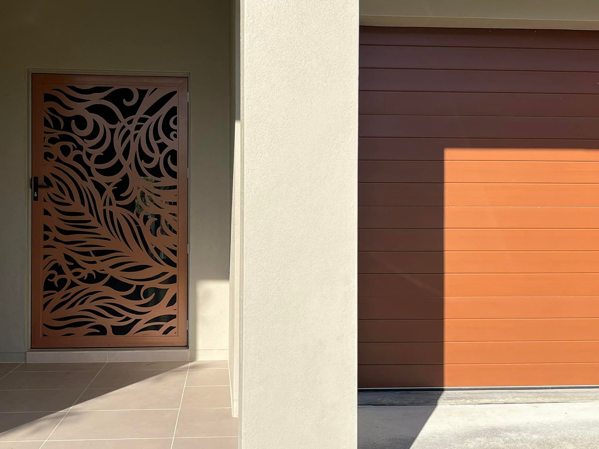 A Door With a Pattern on It is Next to a Garage Door — Whitsunday Blinds & Security In Beaconsfield, QLD