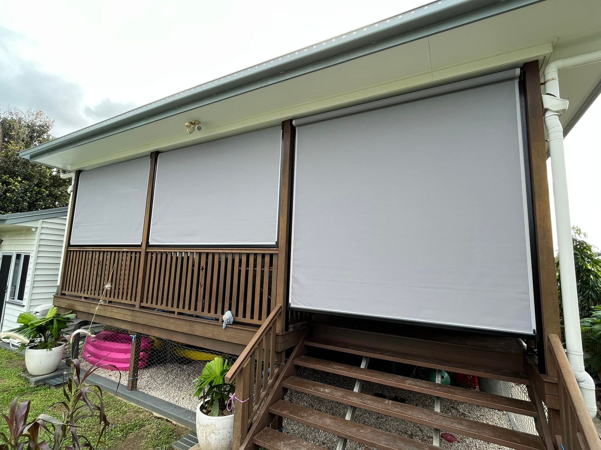 A House With a Wooden Deck and Stairs With Blinds — Whitsunday Blinds & Security In Beaconsfield, QLD