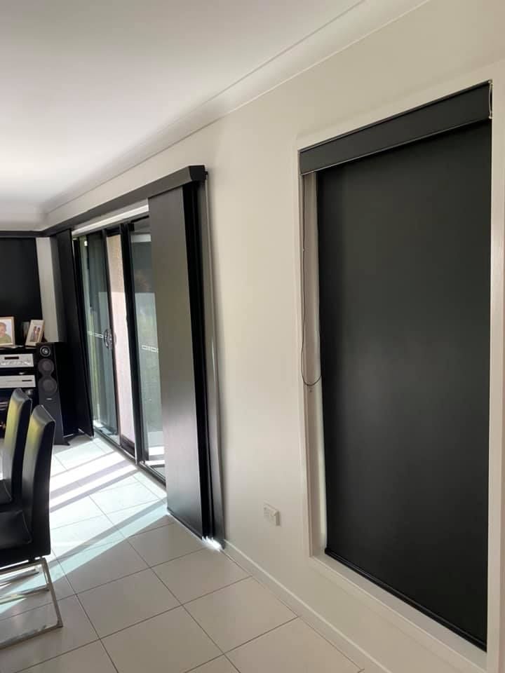 A Living Room With Sliding Glass Doors and Black Blinds — Whitsunday Blinds & Security In Beaconsfield, QLD