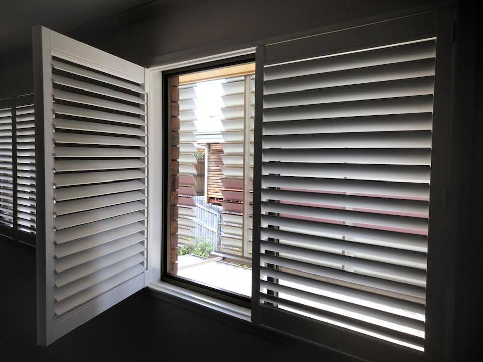 A Window With Shutters on It and a Sliding Glass Door — Whitsunday Blinds & Security in Proserpine, QLD