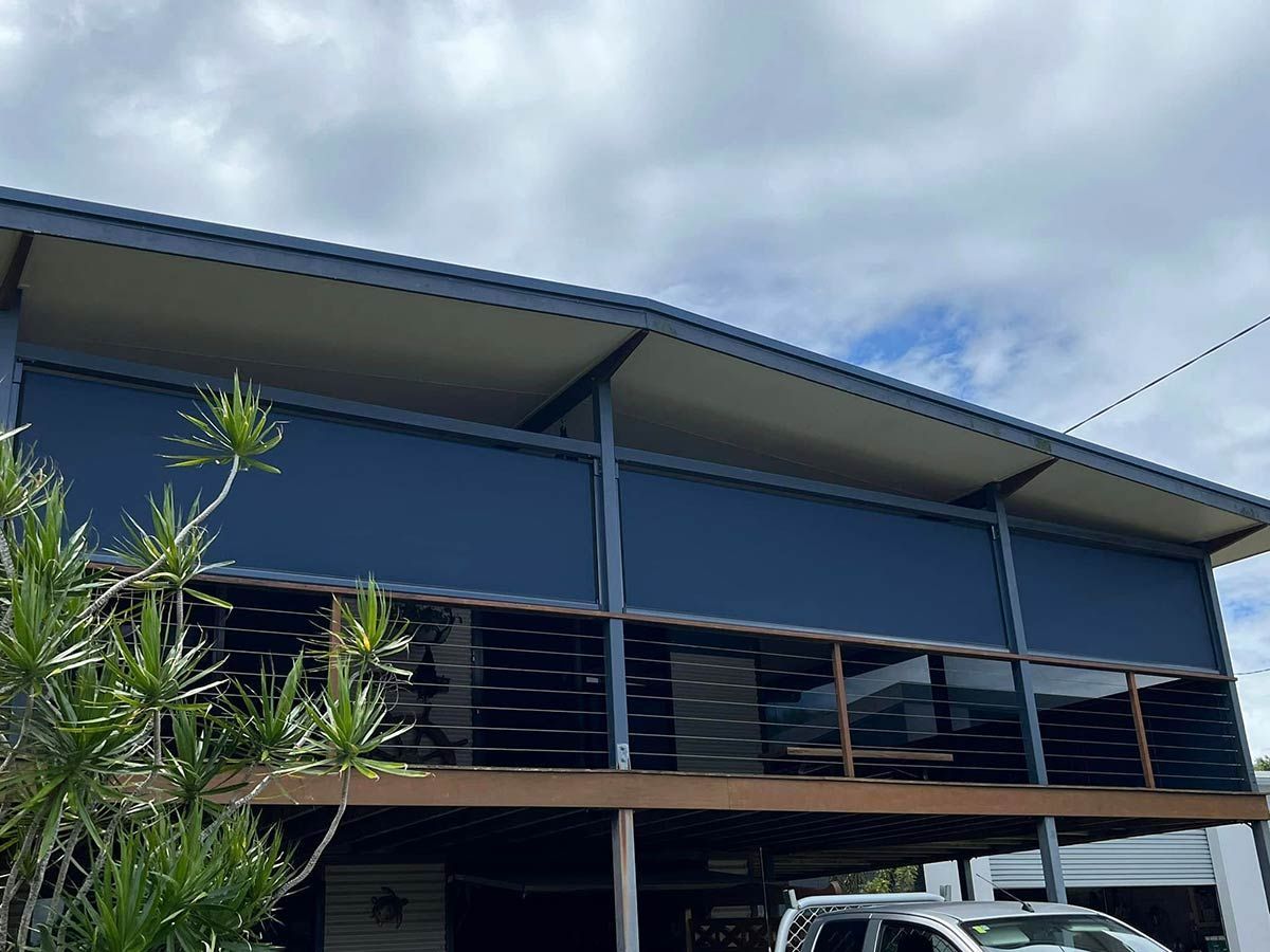 A Blue Building With a Car Parked in Front of It — Whitsunday Blinds & Security In Beaconsfield, QLD