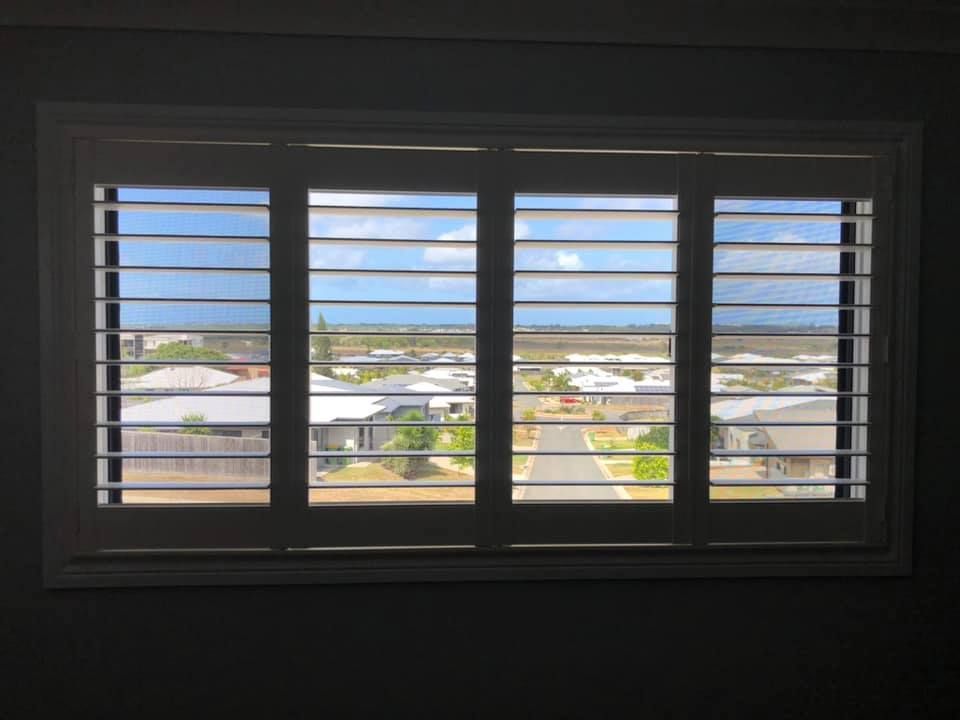 A Window With Shutters Open and a View of a City — Whitsunday Blinds & Security in Airlie Beach, QLD