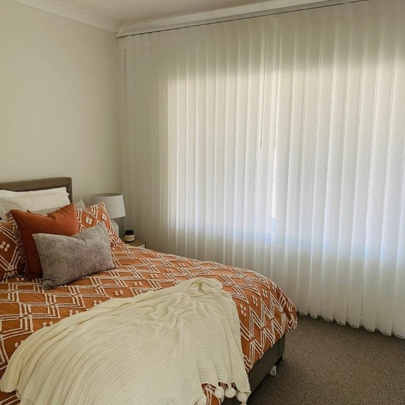 A Bedroom With a Bed and a Window With White Blinds — Whitsunday Blinds & Security in Cannonvale, QLD