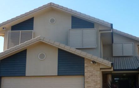 A House With a White Picket Fence in Front of it With Window Shutters — Whitsunday Blinds & Security In Beaconsfield, QLD