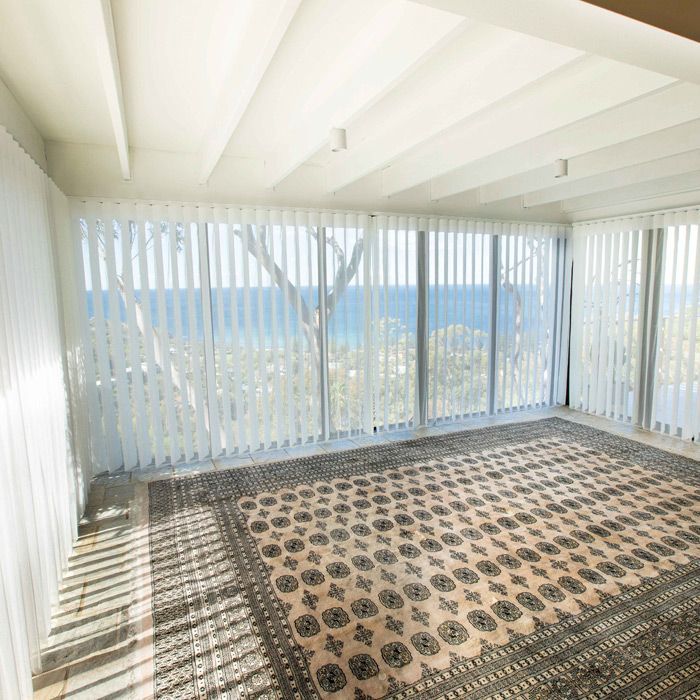 A Living Room With a Rug and Big Windows With Vertical Blinds — Whitsunday Blinds & Security In Beaconsfield, QLD