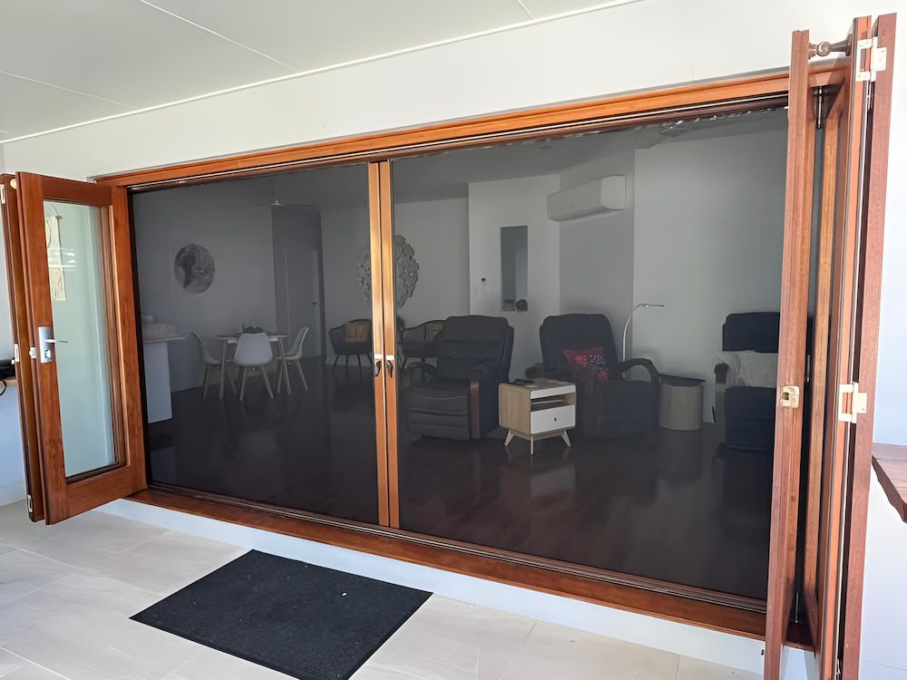 A Bathroom With a Bathtub and a Window With Shutters — Whitsunday Blinds & Security in Cannonvale, QLD