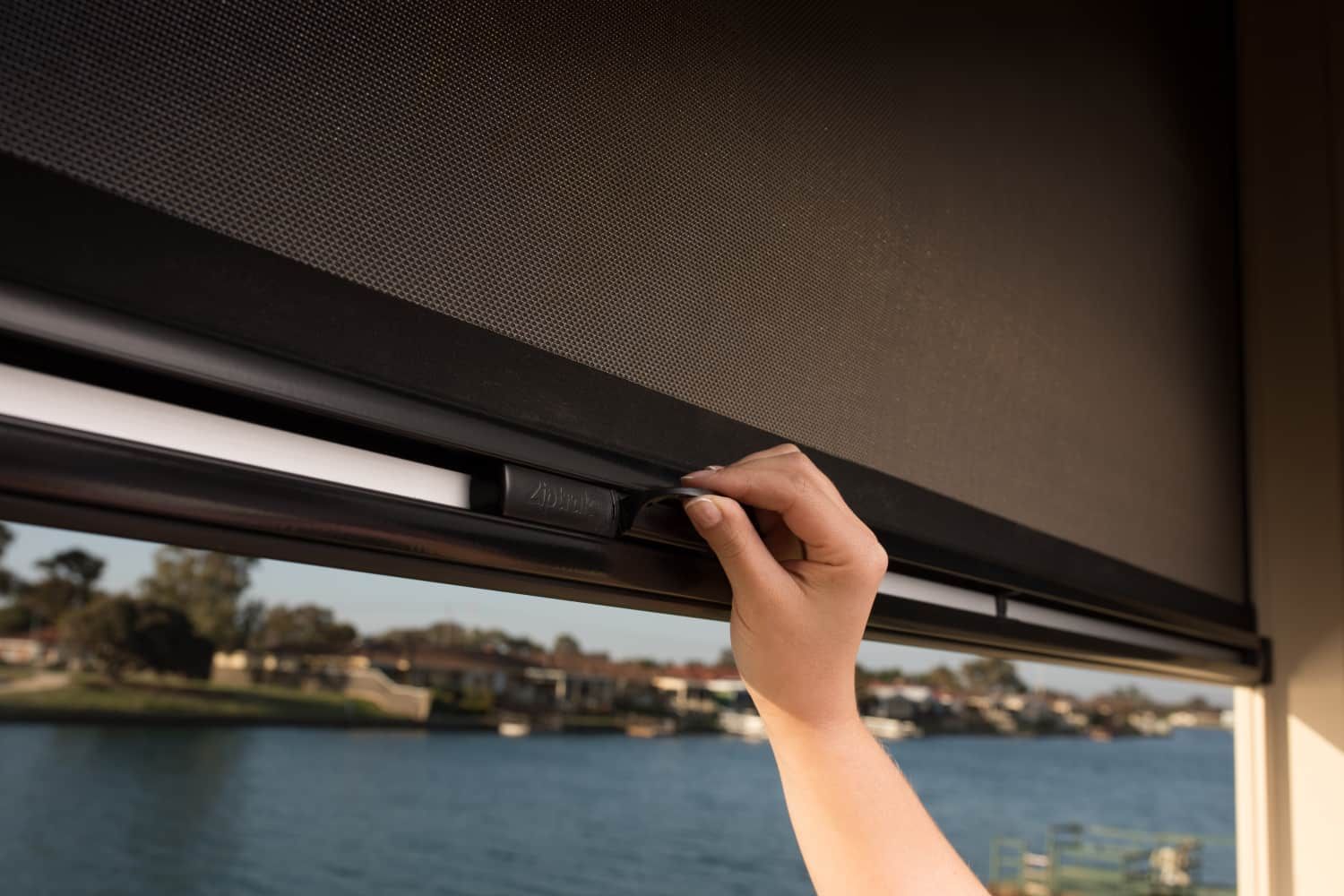 A Man is Standing on a Patio With a Blind on It — Whitsunday Blinds & Security In Beaconsfield, QLD