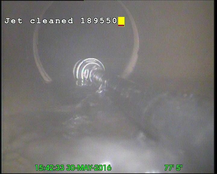 Inside sewer pipe after jet cleaning, water flows.