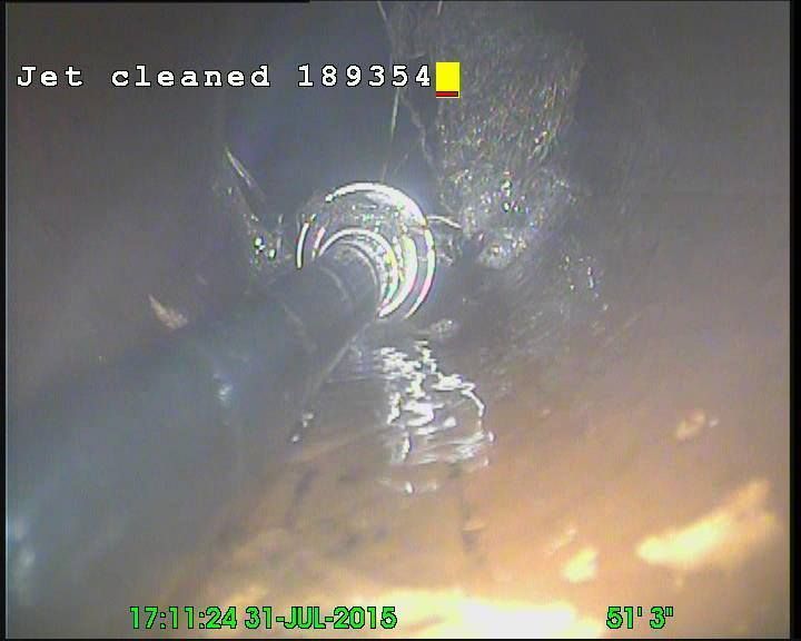 Camera view inside a pipe being cleaned with a high-pressure jet, water spraying, July 31, 2015.