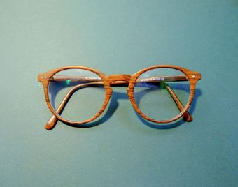 A pair of wooden glasses on a blue surface