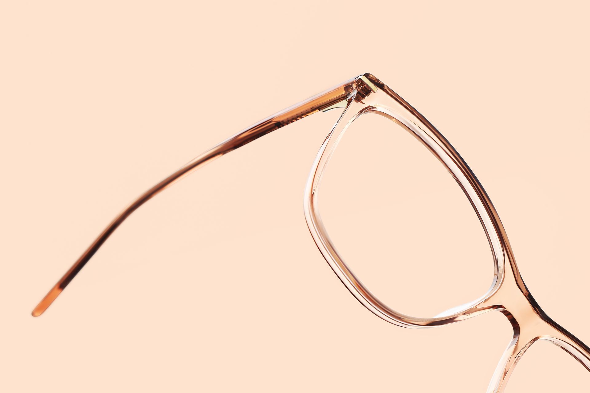 A close up of a pair of glasses on a pink background.