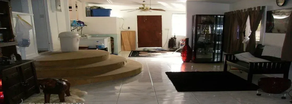Living room with tiled floor, multi-level platform, and dark accents.