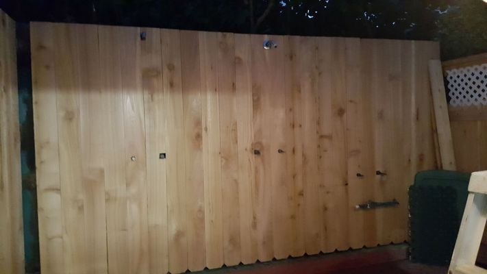 Wooden fence panels outdoors, with visible knots and hardware.