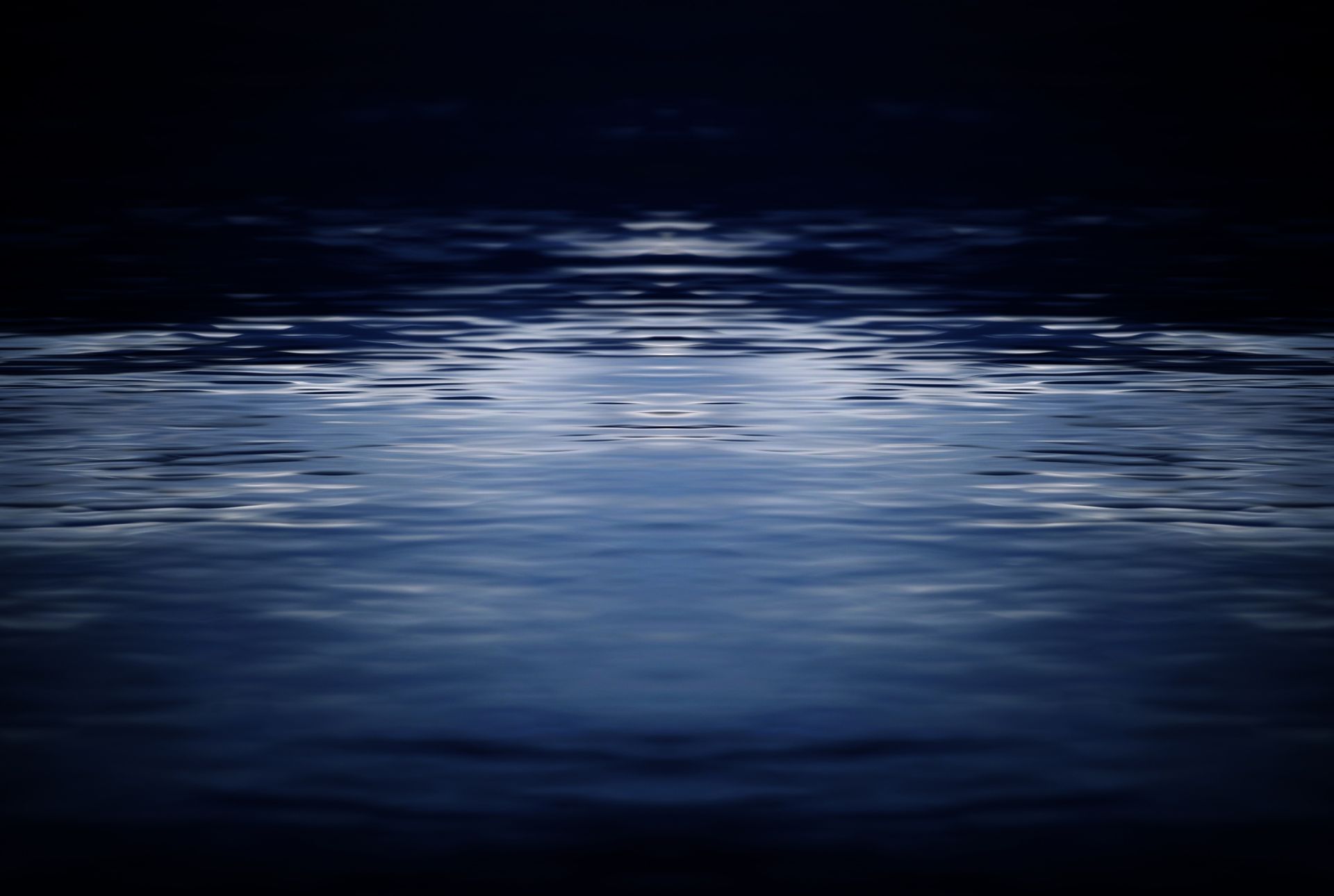 A dark room with a reflection of the moon in the water.