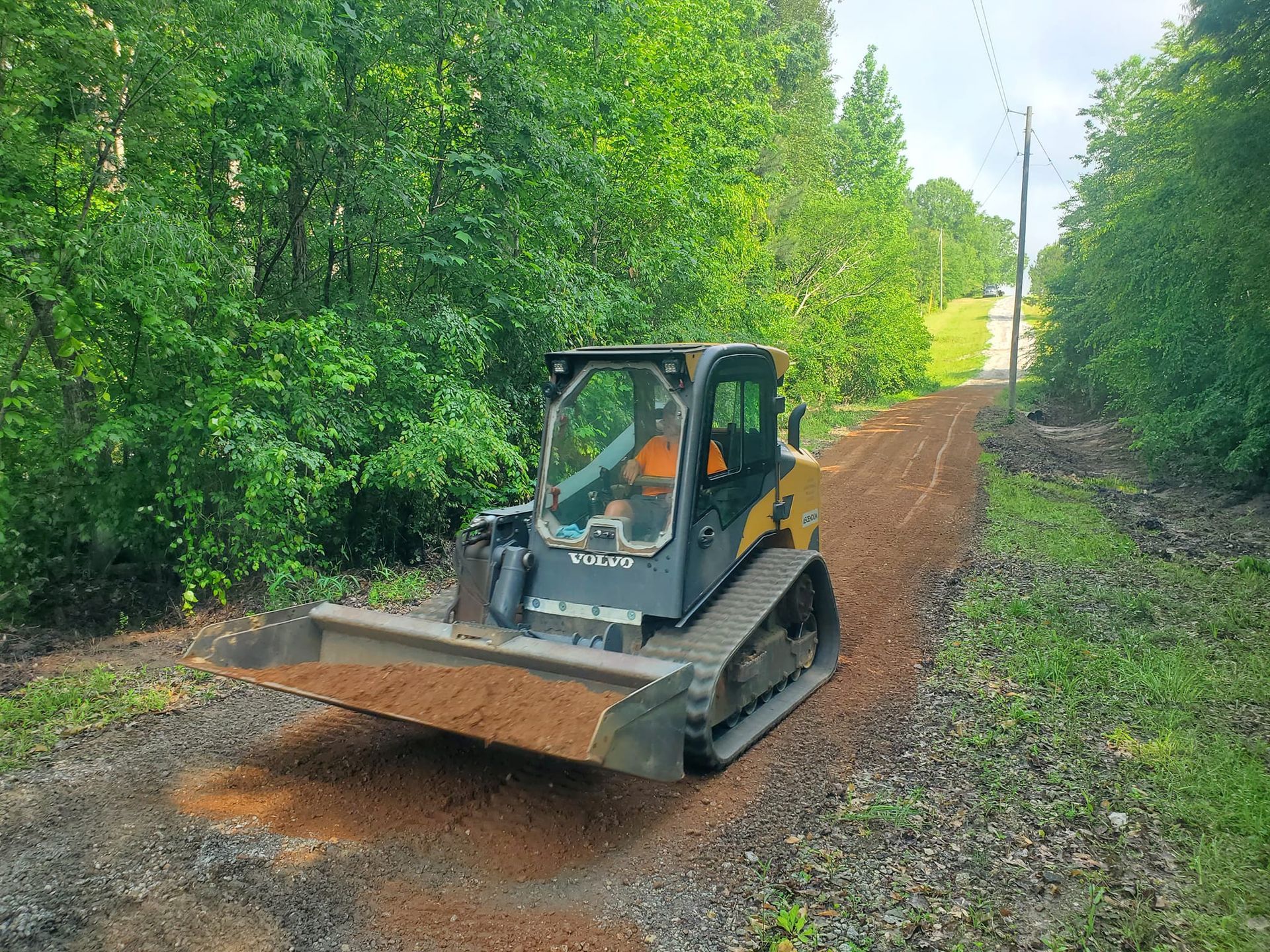 A bulldozer is driving down a dirt road.