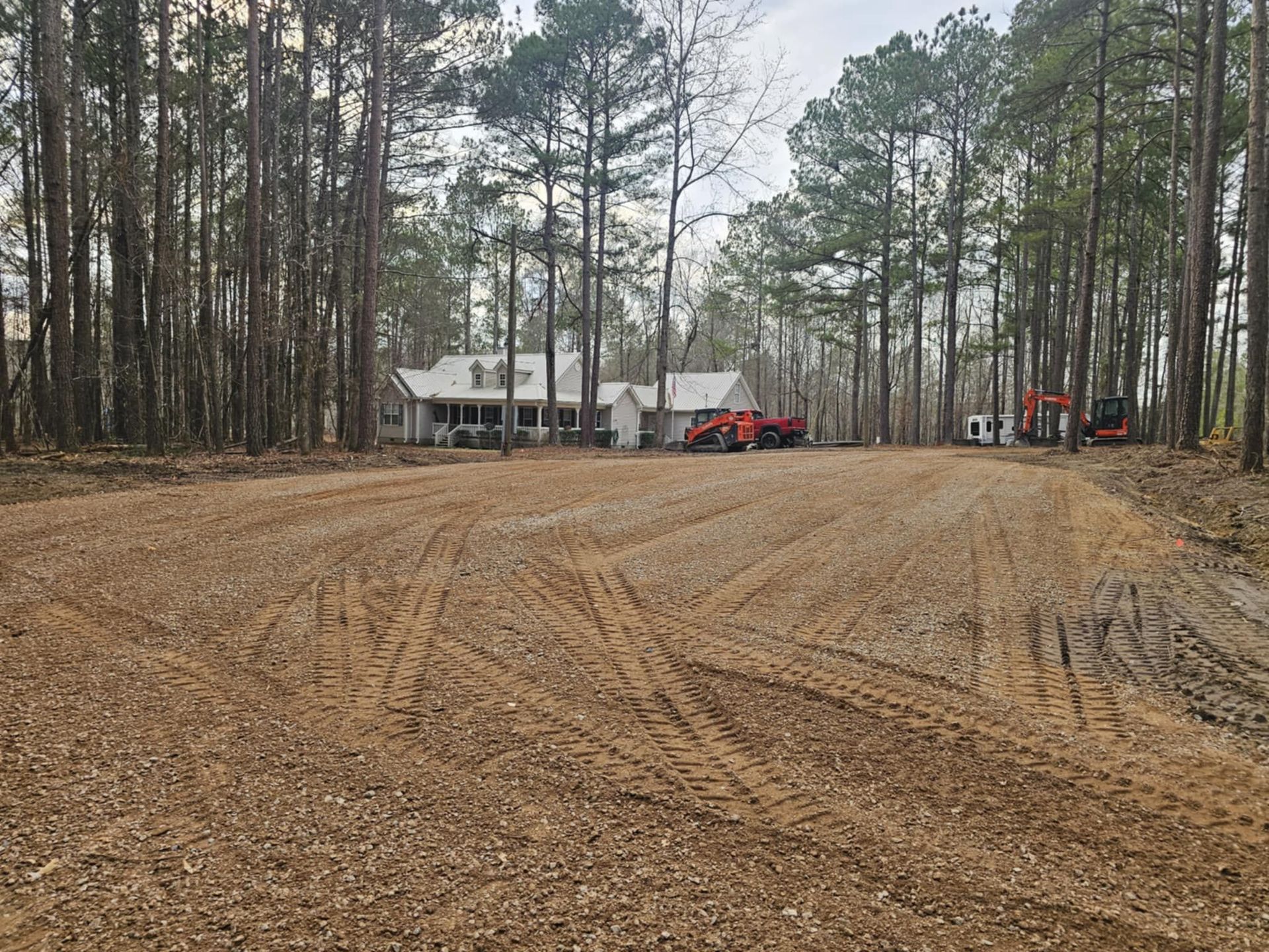 A dirt road leading to a house in the woods.