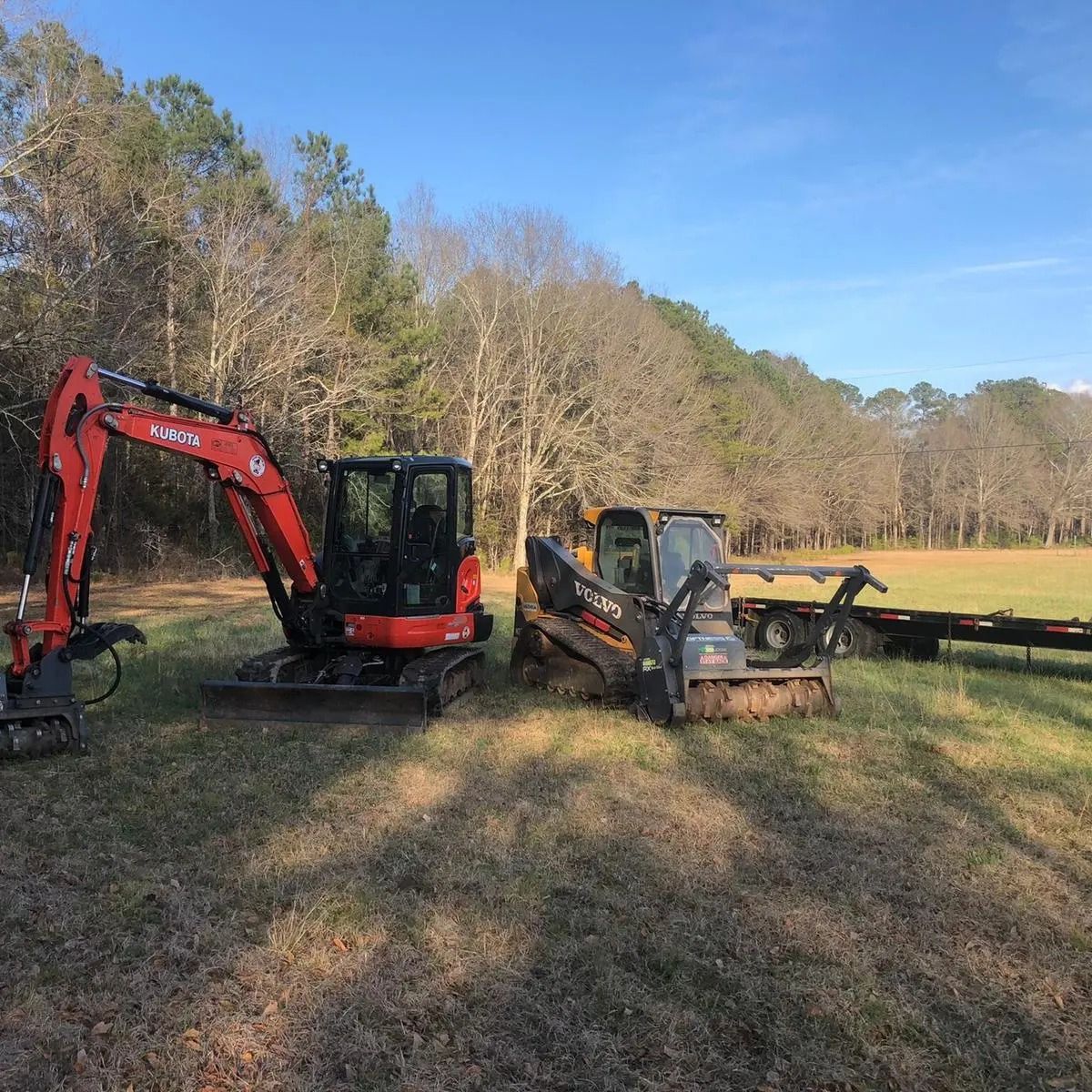 A couple of tractors are parked in a field.