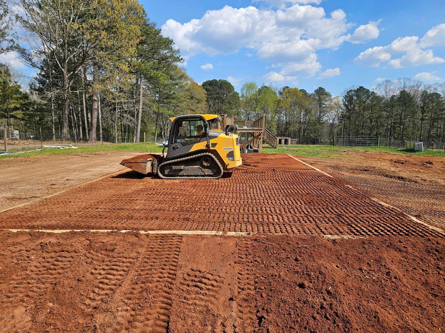 A yellow bulldozer is moving dirt in a field.